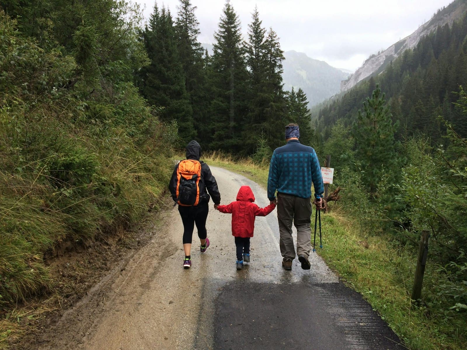 A parent and children walking a mountain path together